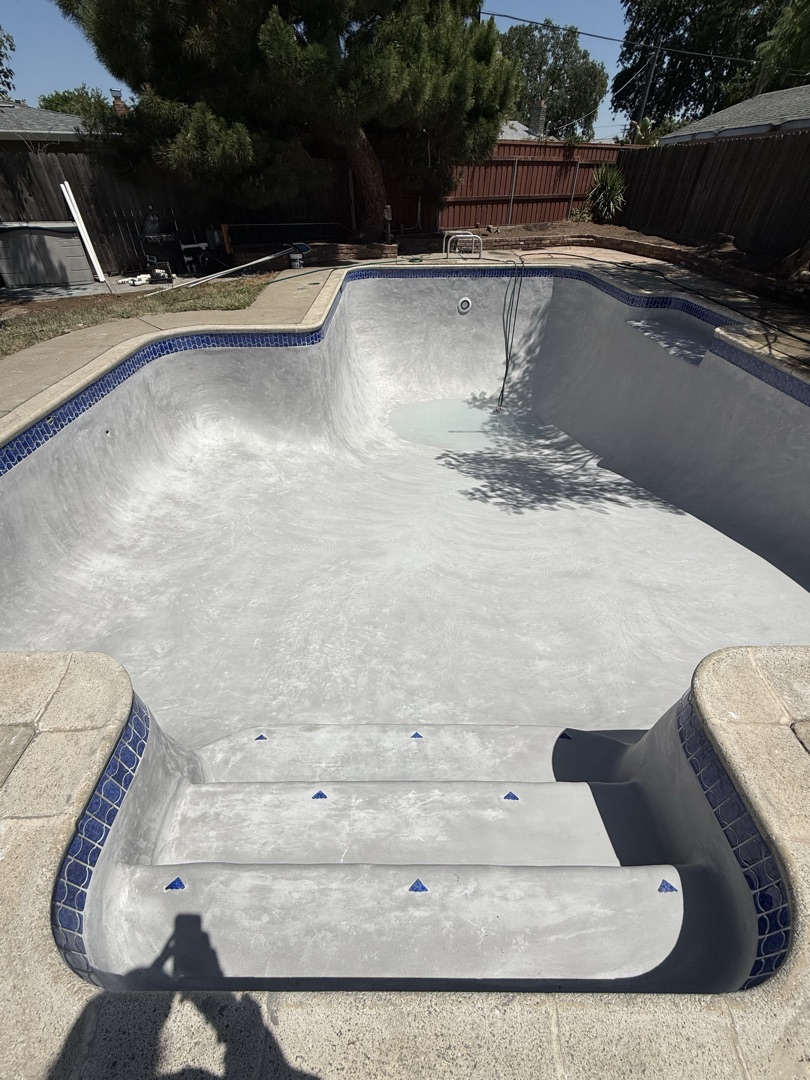 Same pool with fresh smooth gray plaster after replaster
