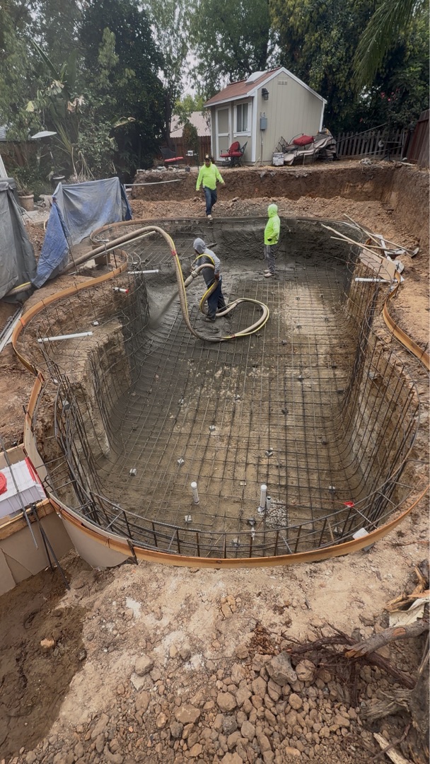 Backyard before new pool installation — dirt and rebar shell during construction