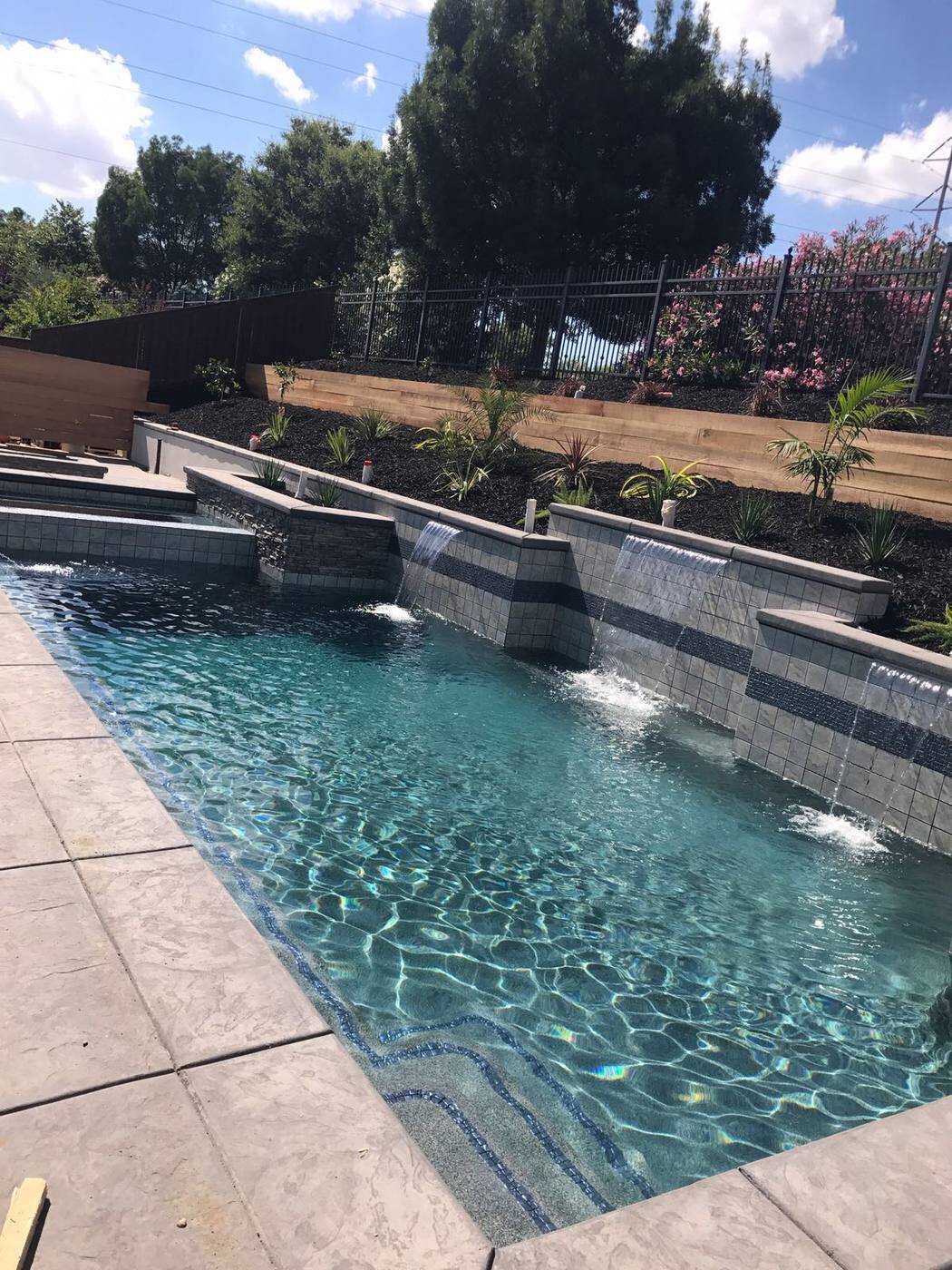 Stunning custom swimming pool with crystal blue water and elegant patio in Sacramento backyard